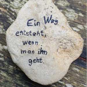 Ein flacher Naturstein mit der Aufschrift „Ein Weg entsteht wenn man ihn geht“ als Inspiration für den Yoga-Kurs in Trossingen.